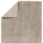 Back corner fold revealing rug’s solid taupe backing and front animal print pattern