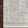 Close-up of the rug corner showing detailed traditional design and soft color blend against dark wood flooring