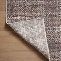 rug corner flipped upward showing light-colored woven backing with grid lines