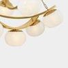 Close-up of smooth opaque white glass shades and gold metal bands in chandelier against light gray background