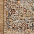 Detail of the rug corner highlighting fringed trim and patterned border on wood floor