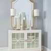 White Neoclassical ceramic obelisk sculpture with intricate carved details and glossy glaze on a white sideboard