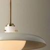 Side angle showing opal glass orb under off white shade with brass stem and pins