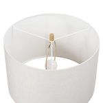 Top-down view inside lamp shade showing bulb, brass harp, and white fabric shade support structure