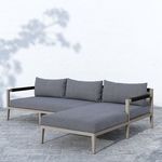 Sectional shown outdoors on stone patio with soft shadow and textured cushions