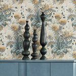 Three bronze vases of varying heights styled on a sideboard against floral wallpaper