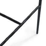 Side close-up of hammered iron frame leg and footrest detail