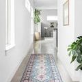 Skye Turquoise Terracotta Rug in narrow hallway with white walls, plants, and framed art