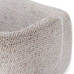 Close-up of rounded upper wingback edge showing textured beige fabric weave