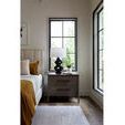 Erinn Nightstand side view in bedroom corner near window with lamp and potted plant on top