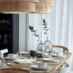 Oval platter shown as part of a styled dining table setting with white dishes, glasses, and natural decor