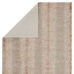 Back flipped corner revealing solid light tan rug backing contrasting front animal print