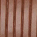 Detailed close-up of smooth chestnut leather surface with subtle grain texture