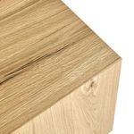 Close-up of textured oak veneer on top corner emphasizing natural wood grain and light finish