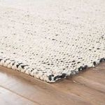 Hand-loomed Almand area rug in natural duo-tone of white, silver, and black with mottled jute texture