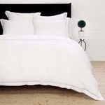 Sheena Bamboo Sateen Euro Sham styled on bed with black headboard and white bedding in room setting