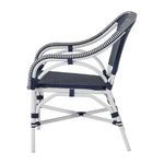 Side view of outdoor lounge chair showing curved back and armrest with navy wicker and white frame