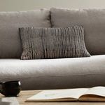 Pillow styled on light beige couch in minimalist living room setting