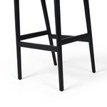 Detailed view of black wooden legs and rectangular foot rails