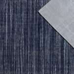 Overhead view of rug front and back corner showing contrasting striped pattern on back