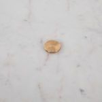 Center brass hardware piece securing marble top with circular shape and brushed finish