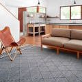Sawyer navy rug styled in modern living room with brown leather and wood furniture on hardwood floor