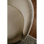 Beige boucle fabric close-up on sofa arm showing soft, looped texture and rounded silhouette
