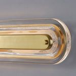 Close-up side angle emphasizing aged brass bar and glass detail with visible light reflections