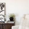 Origins Plaid Cream Pillow styled on armchair in neutral living room setting