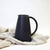Thomas Black Garden Pitcher styled upright on beige fabric cloth background