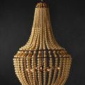 Side angle of Penelope Beige Chandelier hanging against black backdrop with lights on