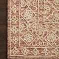 Close-up corner view highlighting Cecelia Rust Natural Rug's wool texture and intricate beige floral border pattern