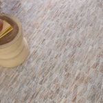 Close view of rug near side table displaying intricate trellis design and textured surface