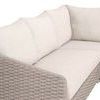 Close-up of sofa corner showing curved woven taupe rope arm and beige fabric cushions