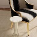 Styled room with Osa Drinks Table positioned next to a black and white upholstered chair on beige carpet