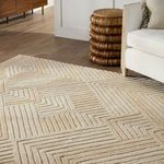 Close-up angle of rug beside white chair and woven stool showing geometric wool pattern and pile