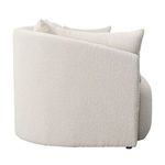 Side view highlighting the sofa's curved back and textured cream fabric upholstery