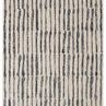Hand-tufted Nikki Chu rug with abstract vertical black lines on a cream background, modern global design