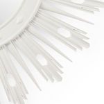 Close-up of white lacquer starburst mirror showing textured spikes and cut-out details