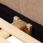 Close-up showing wooden slat support system attached to black fabric and camel upholstery