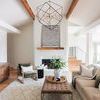 Black Dots Framed Art hanging above a fireplace in a modern living room with wooden beams and neutral décor