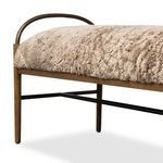 Low angled side detail showing amber ash legs and black metal support stretcher beneath shearling seat
