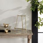 Side view of Baldwin Easel displayed on rustic wooden table near window with green leaves