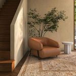Devlin lounge chair in sunlit corner near stairs and window with wall art and small side table