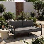 Sherwood sofa in sunny garden setting with stone floor, greenery, and white side table with coffee.