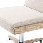 Close-up of chair seat cushion with woven fabric texture and wood frame edge