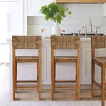 Three Haven stools styled at kitchen island with marble backsplash and green vase centerpiece