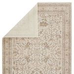 Rug styled with beige sofa and wood coffee table featuring metal frame in softly lit room.