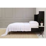 Side view of the Sheena Bamboo Sateen Sheet Set showing the full length drape and bed frame details in a minimalist bedroom