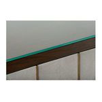Close-up detail of clear glass top edge and brass spine against textured gray shagreen leather doors